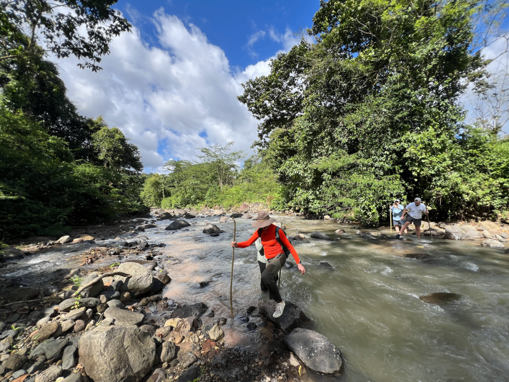 Guests crossing the river on foot below the ranch