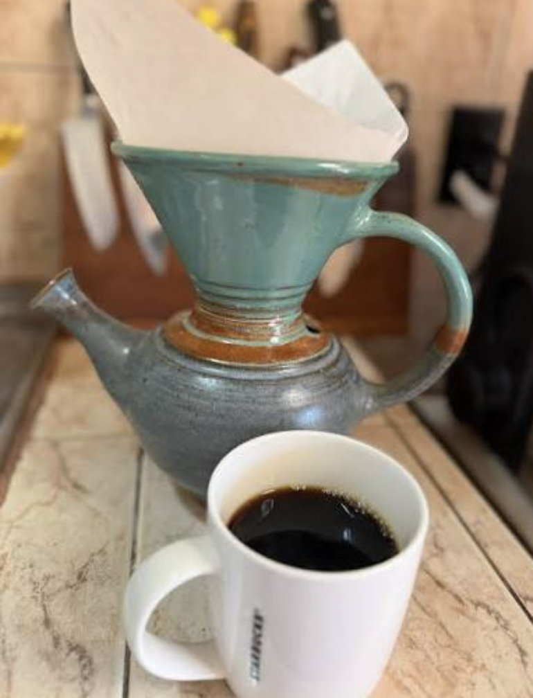 Hand-poured Costa Rican coffee dripping through a ceramic pour-over into a mug