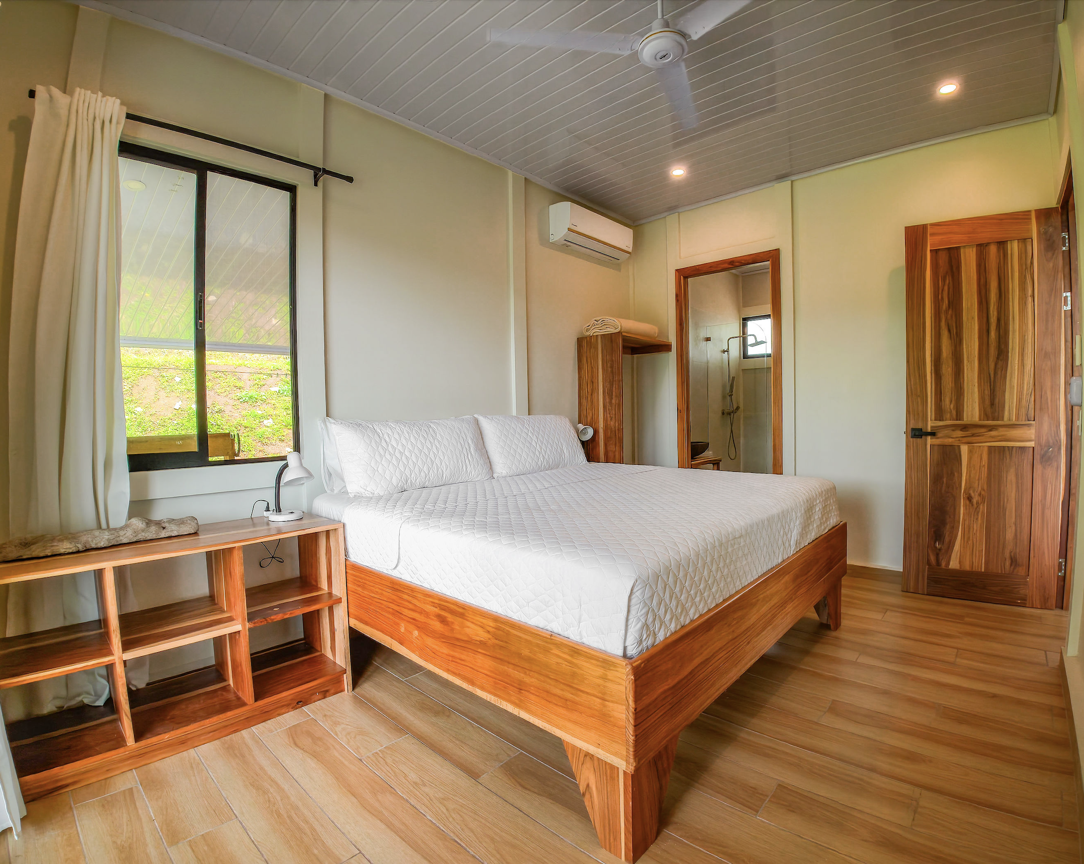 King bedroom with handcrafted teak bed and en suite bath